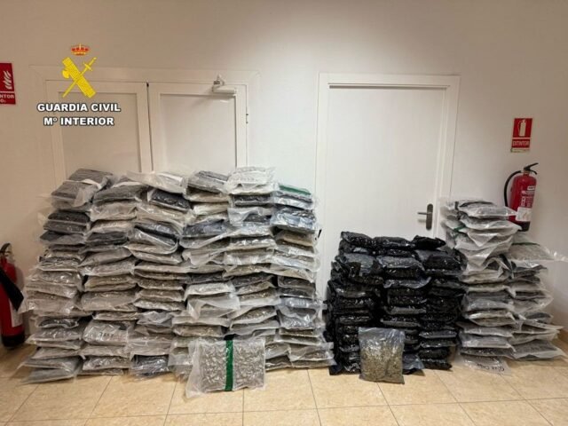 Policía fuera de servicio cajas de manchas llenas de marihuana que se están cargando para un largo viaje fuera de España
